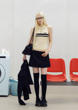 Black low-rise A-line mini skirt styled with an ivory lace camisole