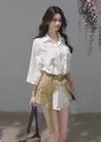 Model wearing a white shirt dress with a natural lace-up waist cincher