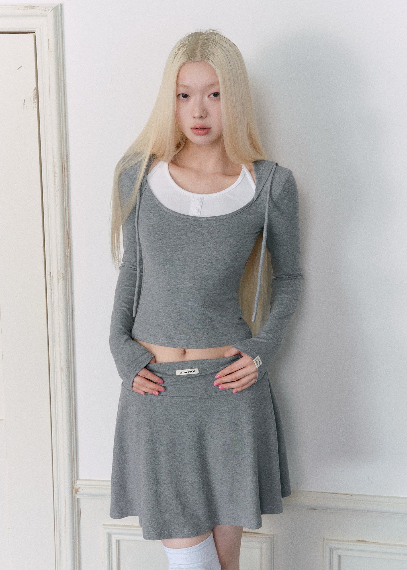 Gray hooded waist-cinching top with a coordinating pleated mini skirt