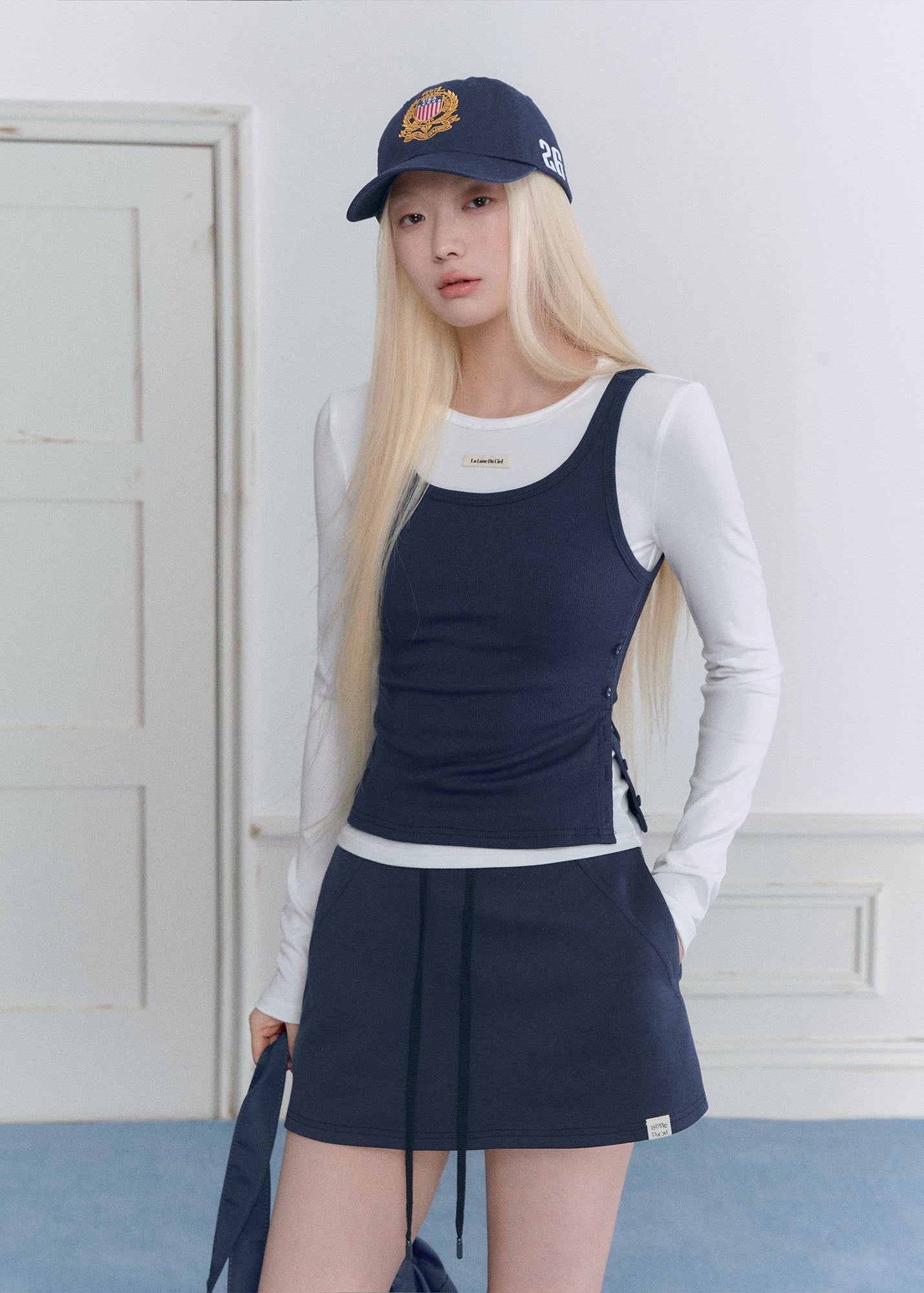 Model wearing a navy and white faux-layered top with a drawstring mini skirt