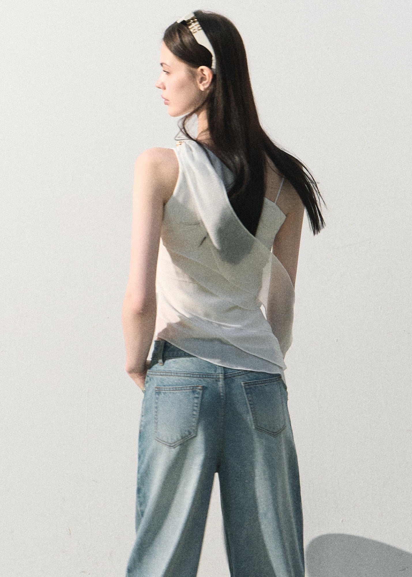 White waist-defining top with an elegant one-shoulder neckline