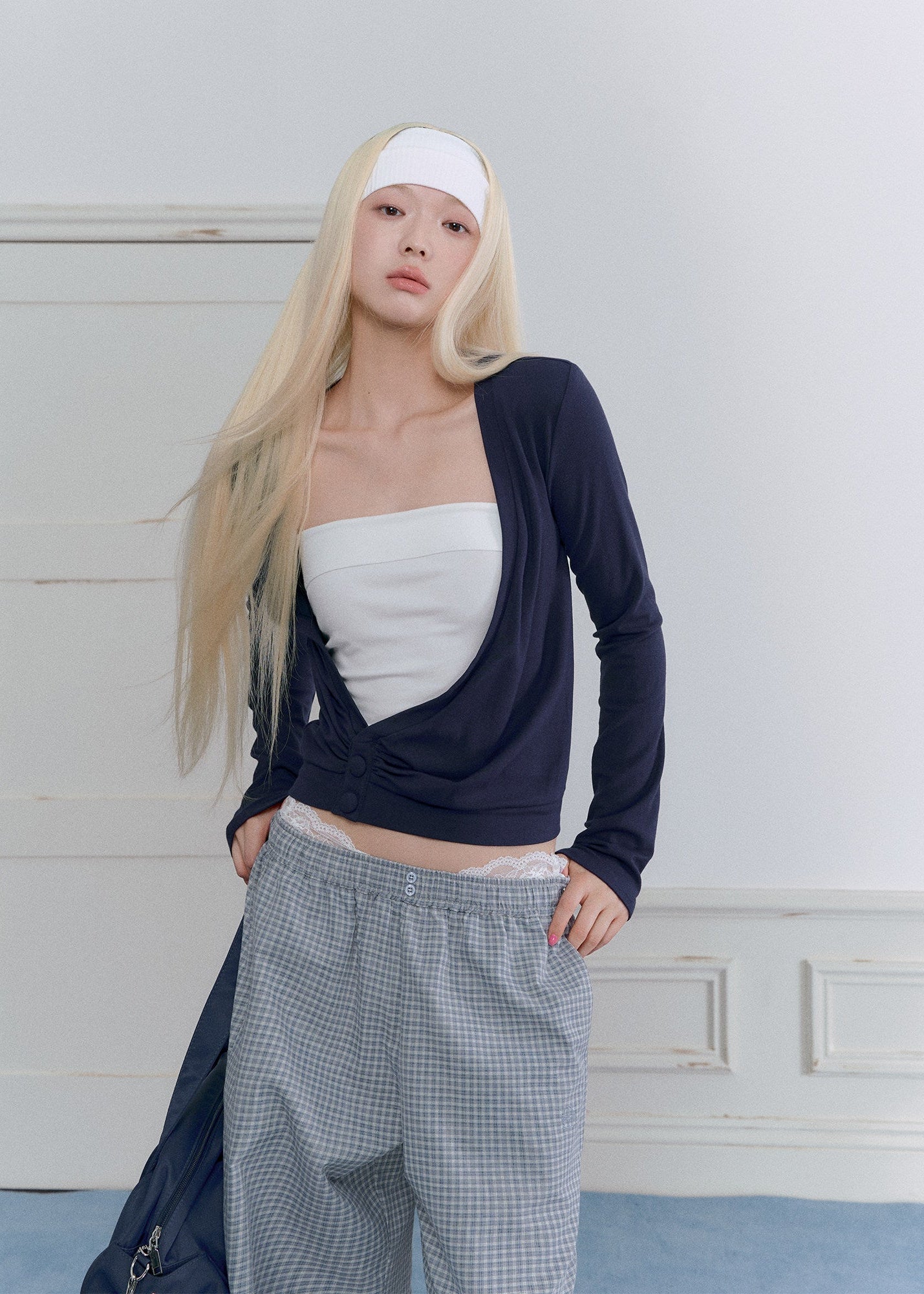 Model wearing a sky-blue asymmetric cross-twist knit top