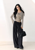 Dark indigo pleated wide-leg trousers with a foldover waist