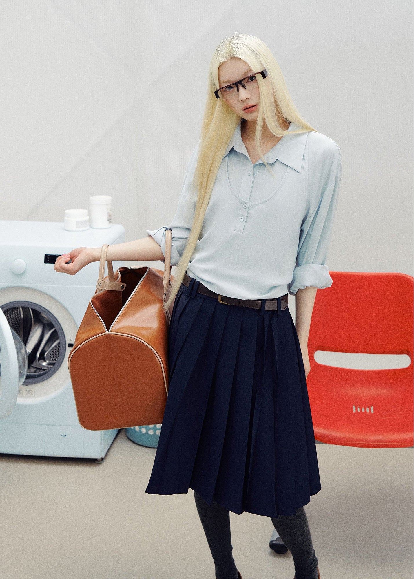 Navy pleated skirt with an asymmetric hem styled with knee-high socks and brown loafers