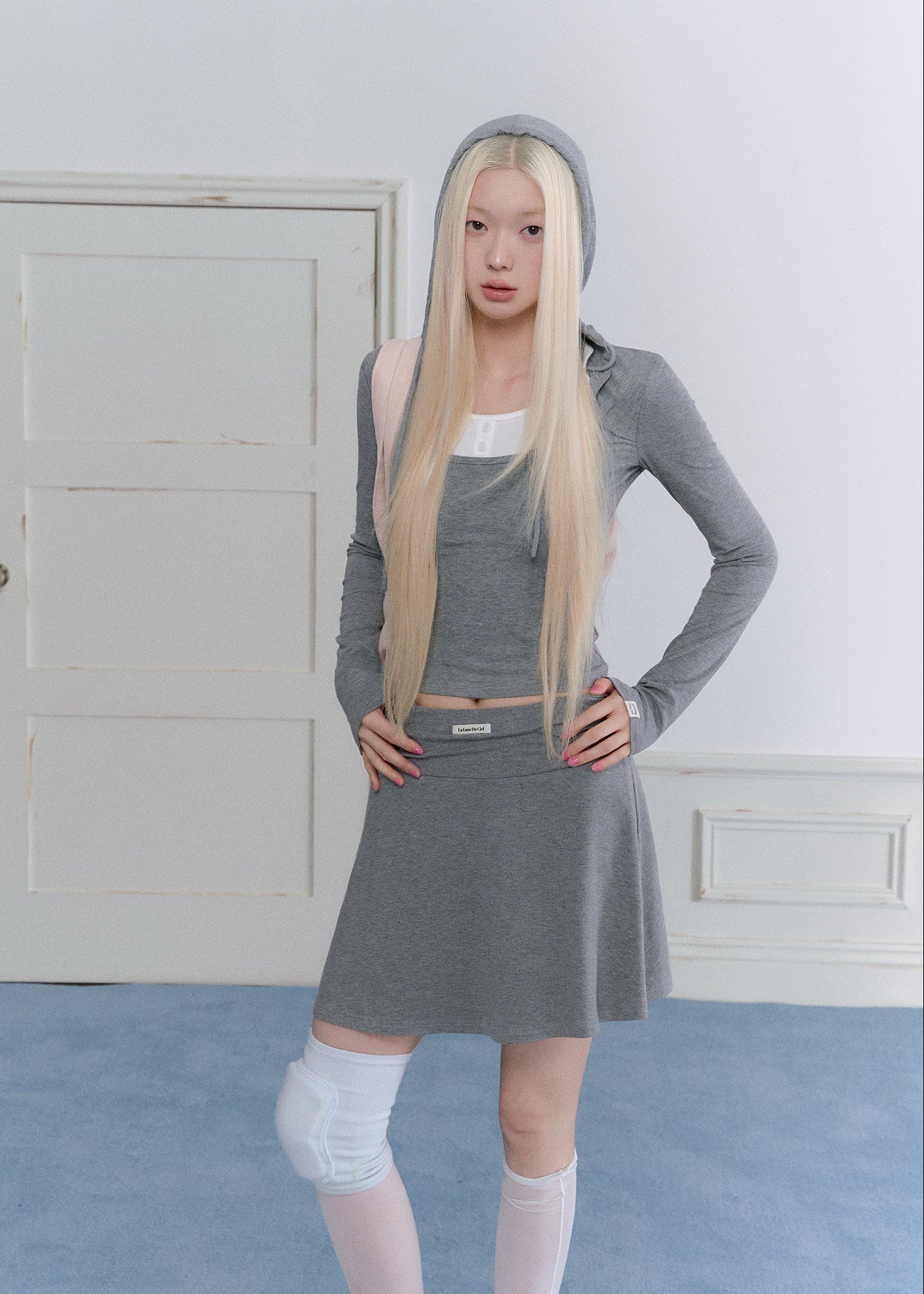 Gray hooded waist-cinching top with a coordinating pleated mini skirt