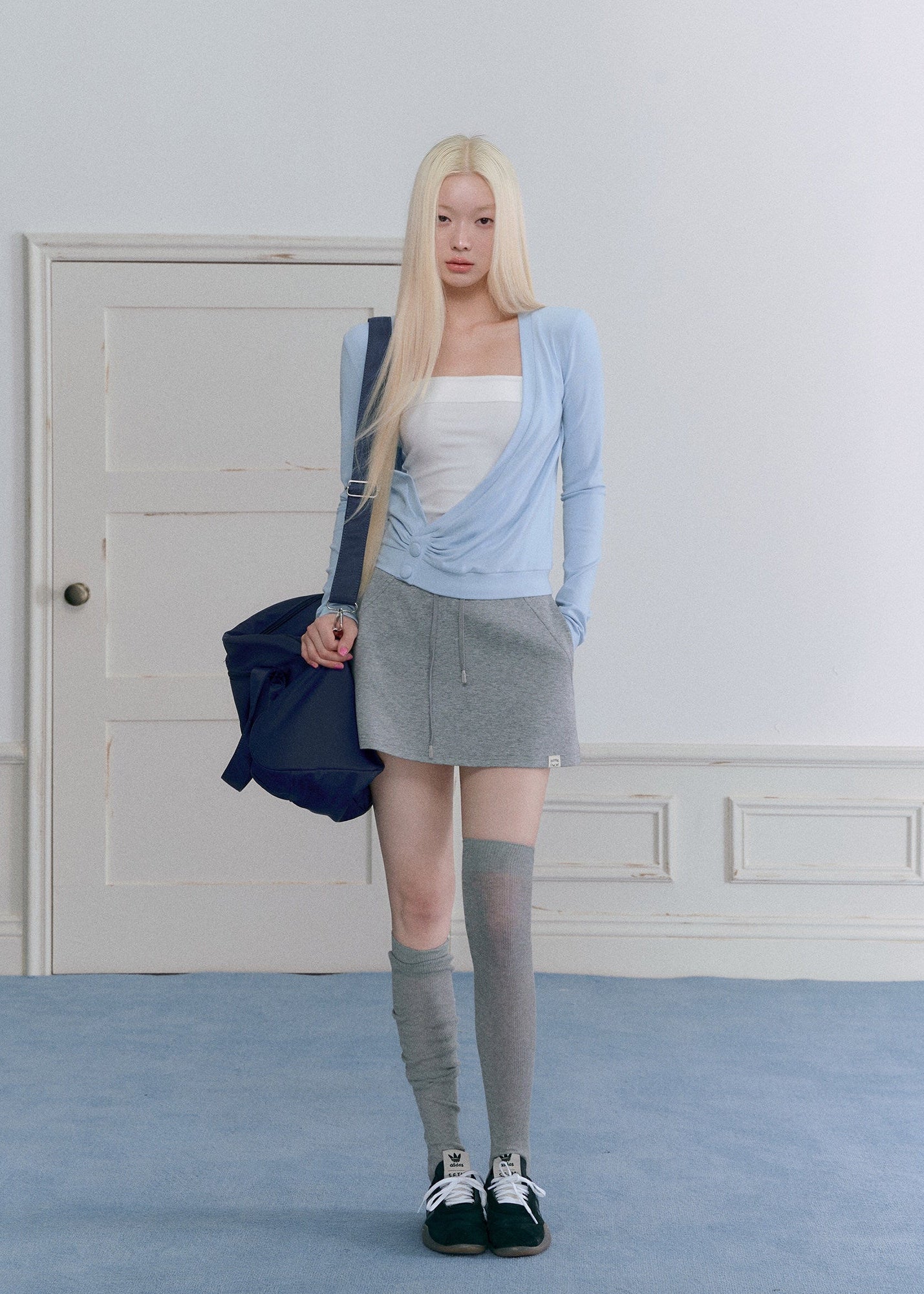 Women’s waist-defining blue knit top with an asymmetric neckline