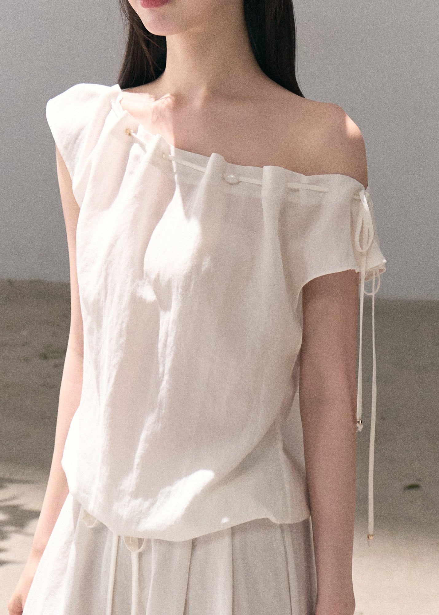Asymmetric off-shoulder top styled with relaxed pants
