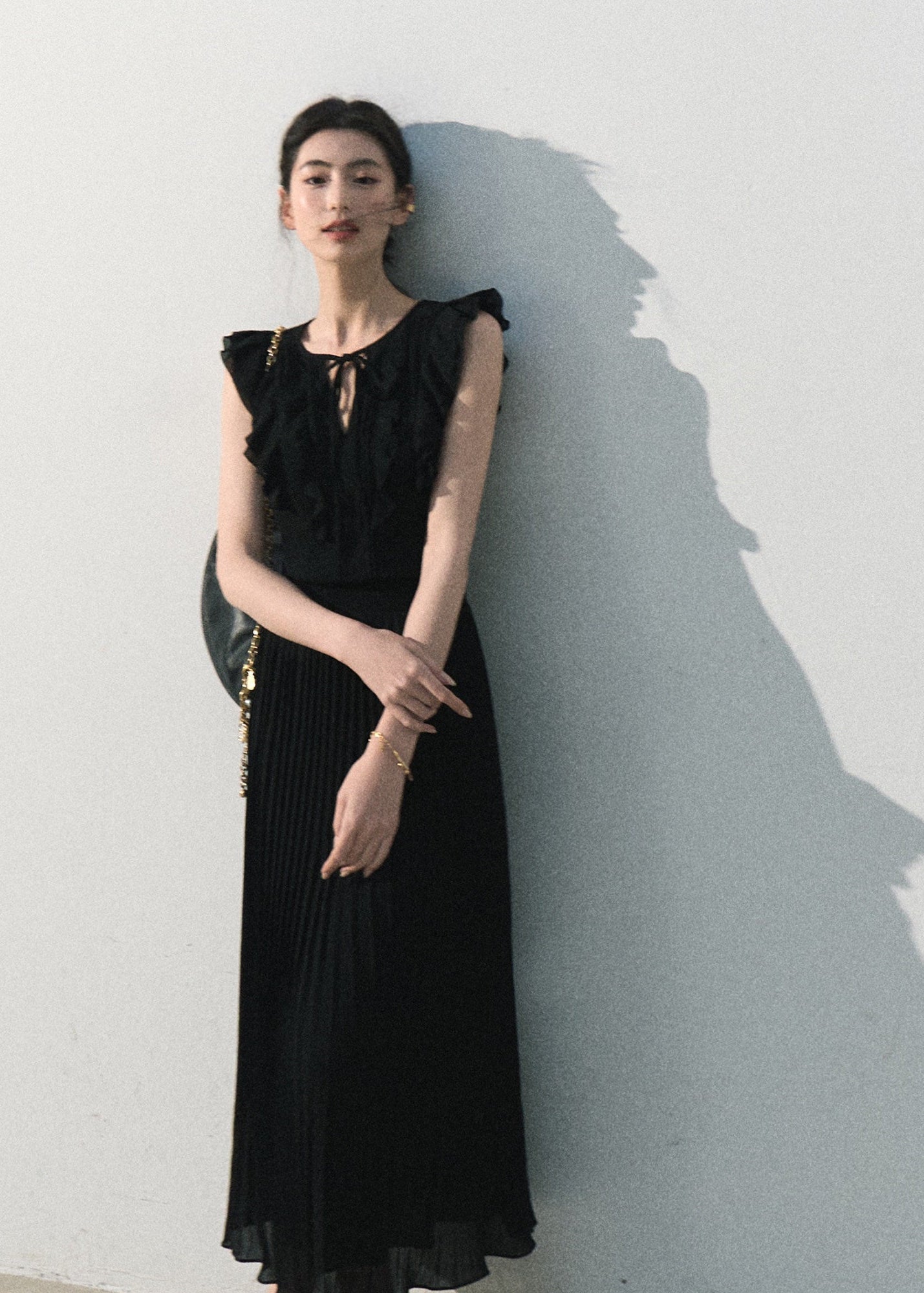 Model wearing a white ruffle dress with a pleated long skirt
