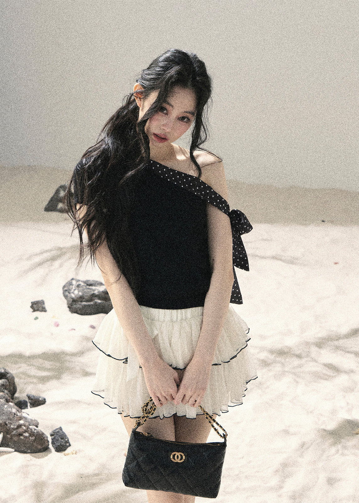 Black one-shoulder knit top with polka dot ribbon bow detail