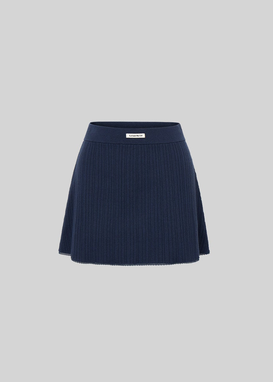 Fitted black knit cardigan and camisole styled with a matching mini skirt