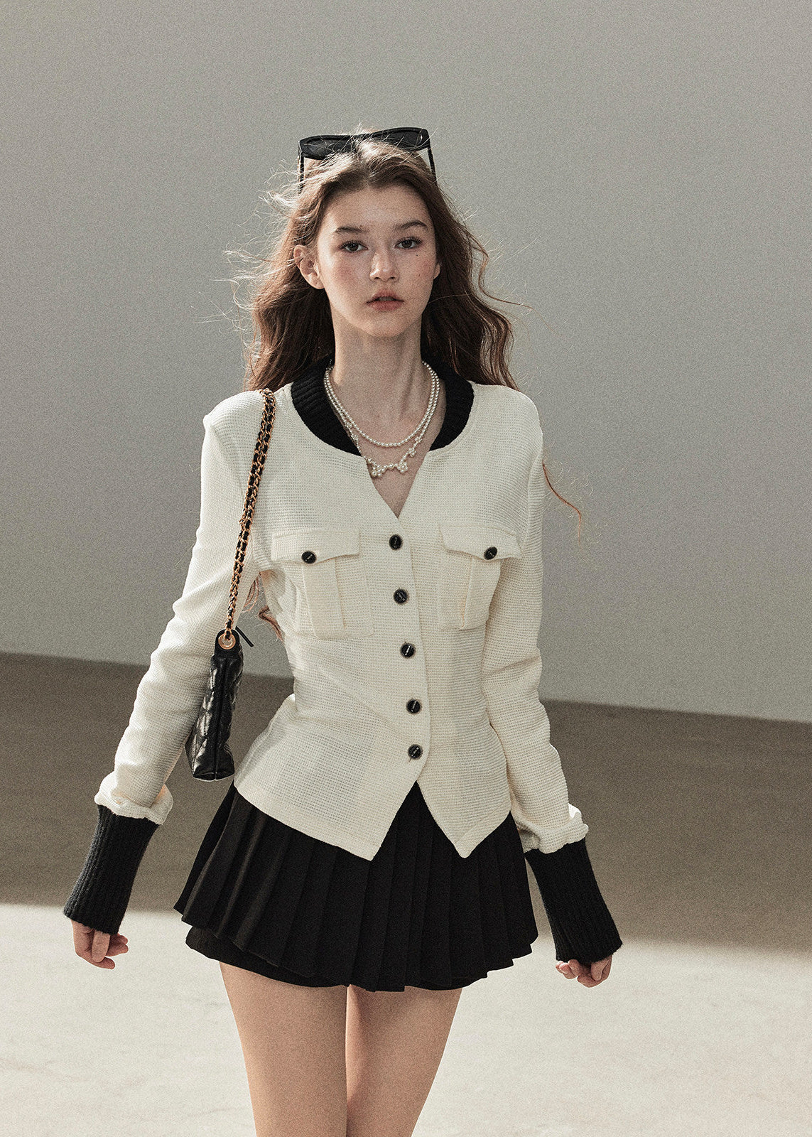 Ivory contrast trim waffle knit cardigan with black pleated mini skirt