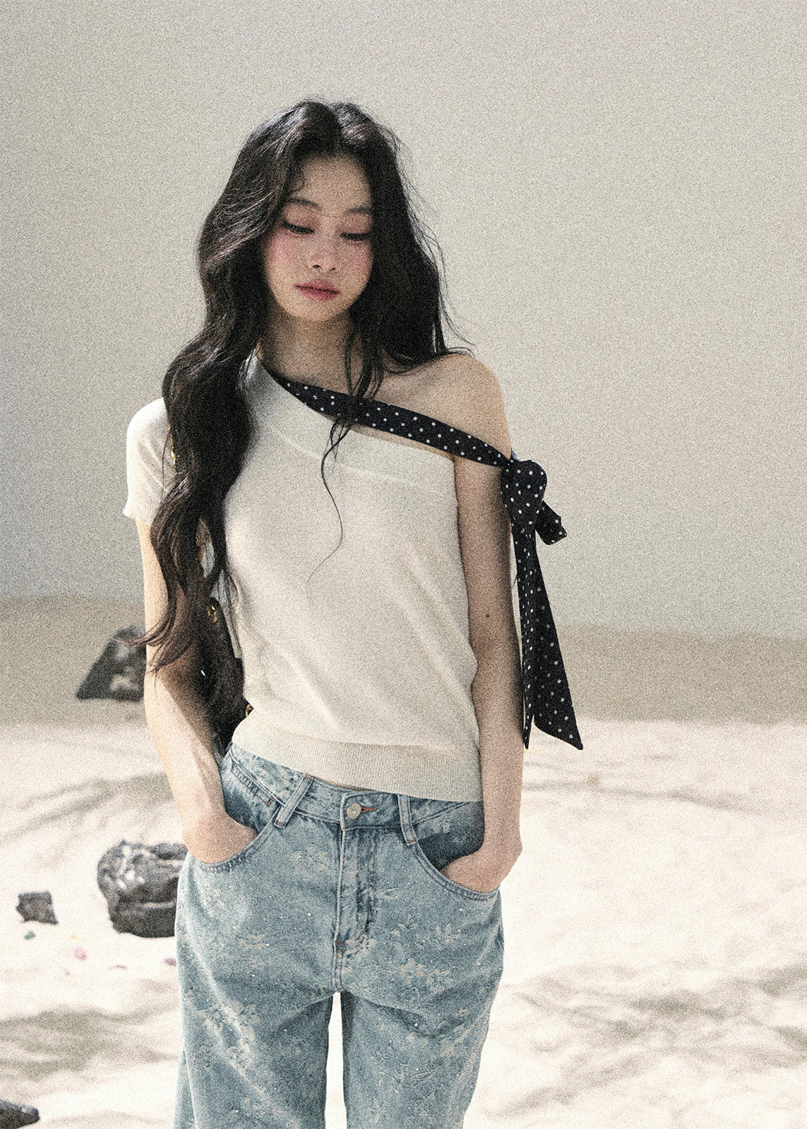 White one-shoulder knit top with black polka dot ribbon detail