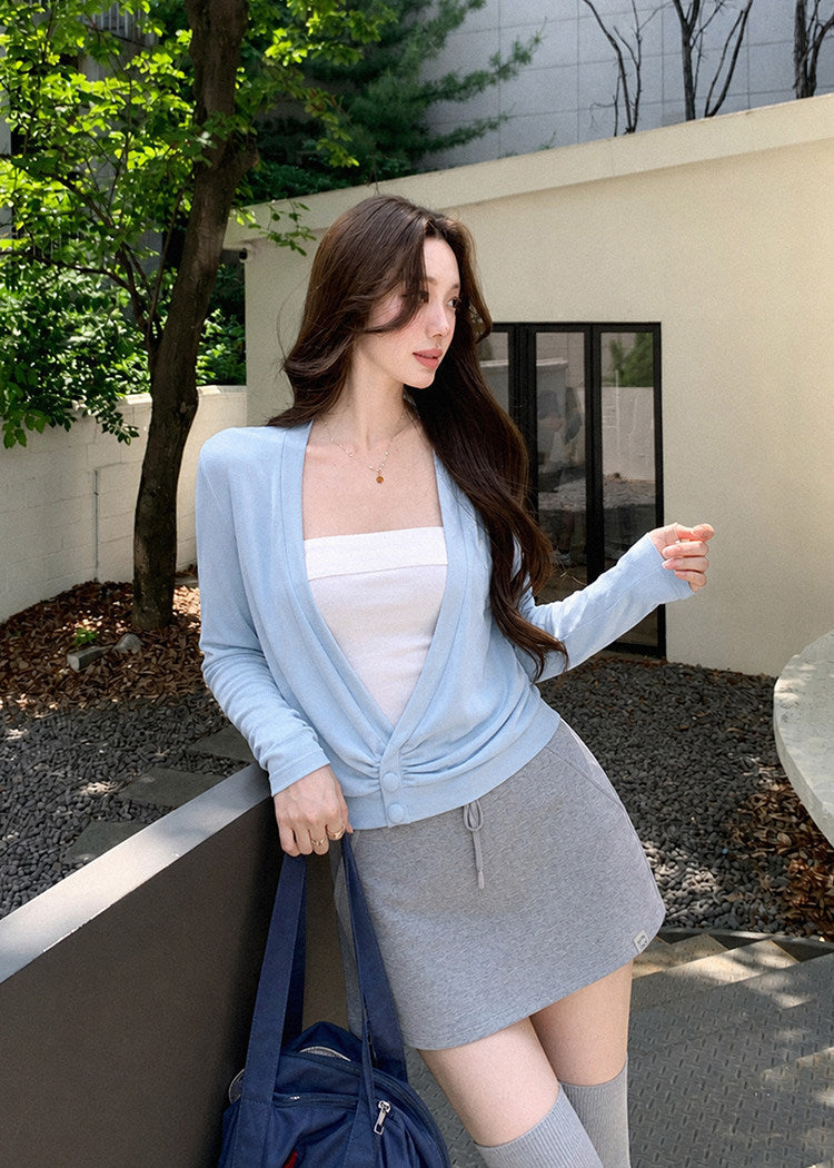 Women’s waist-defining blue knit top with an asymmetric neckline