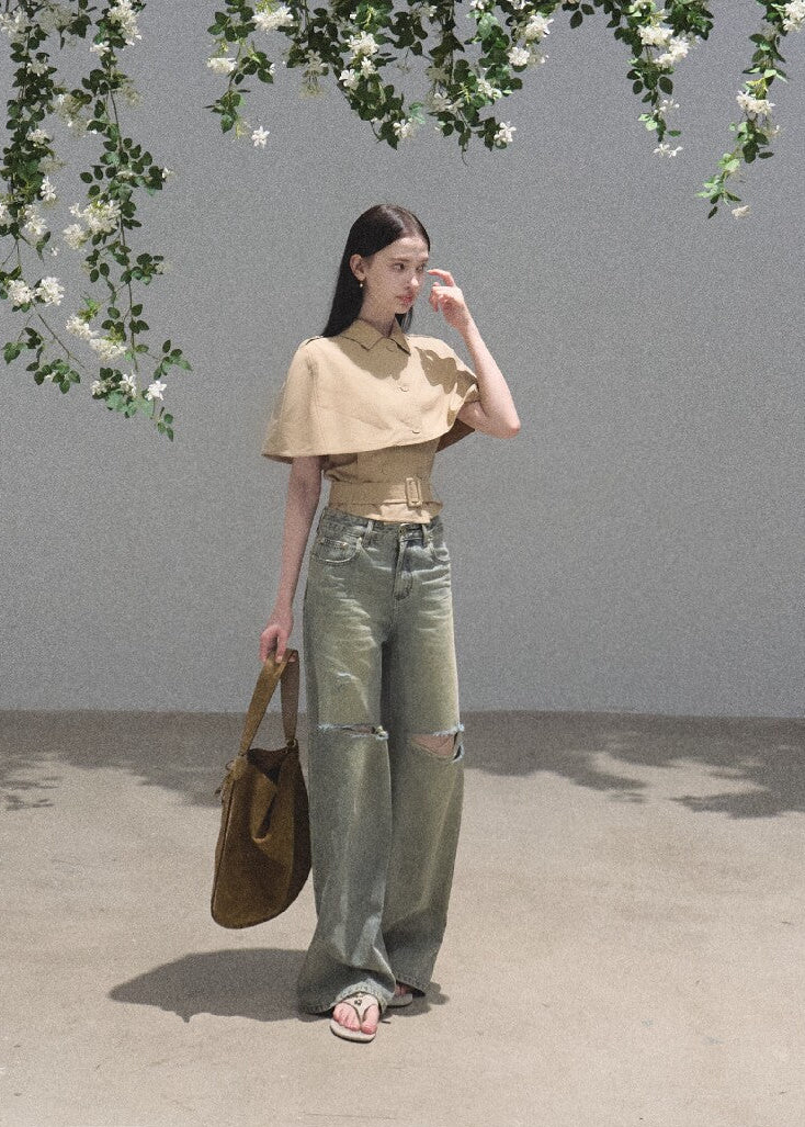 Cropped collared cape layered over a waist-defining sleeveless dress