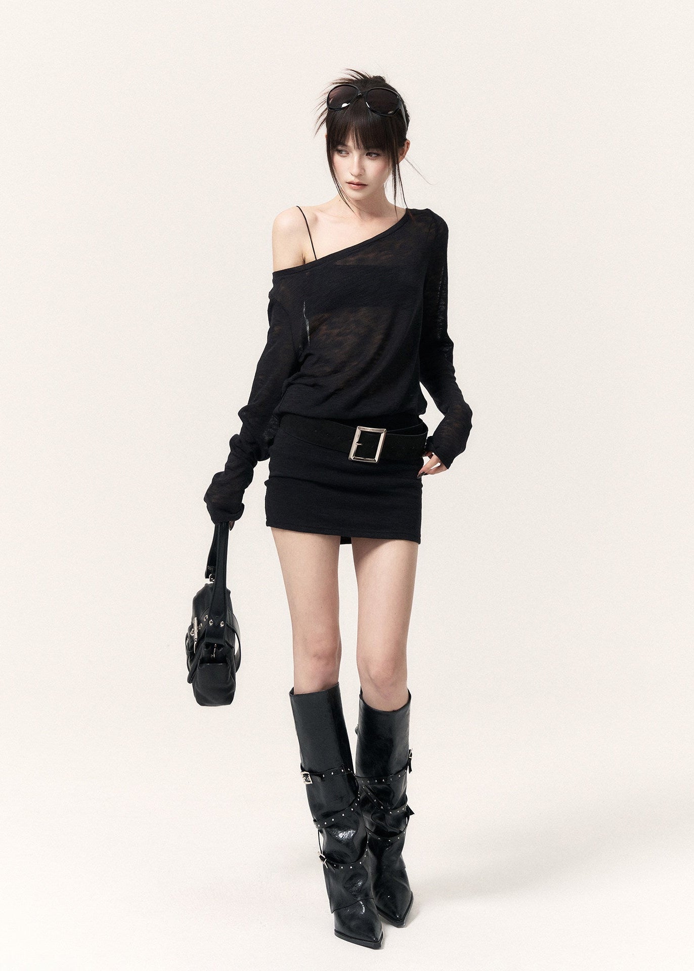 Back view of a black open-back dress with cross straps and a metal pendant