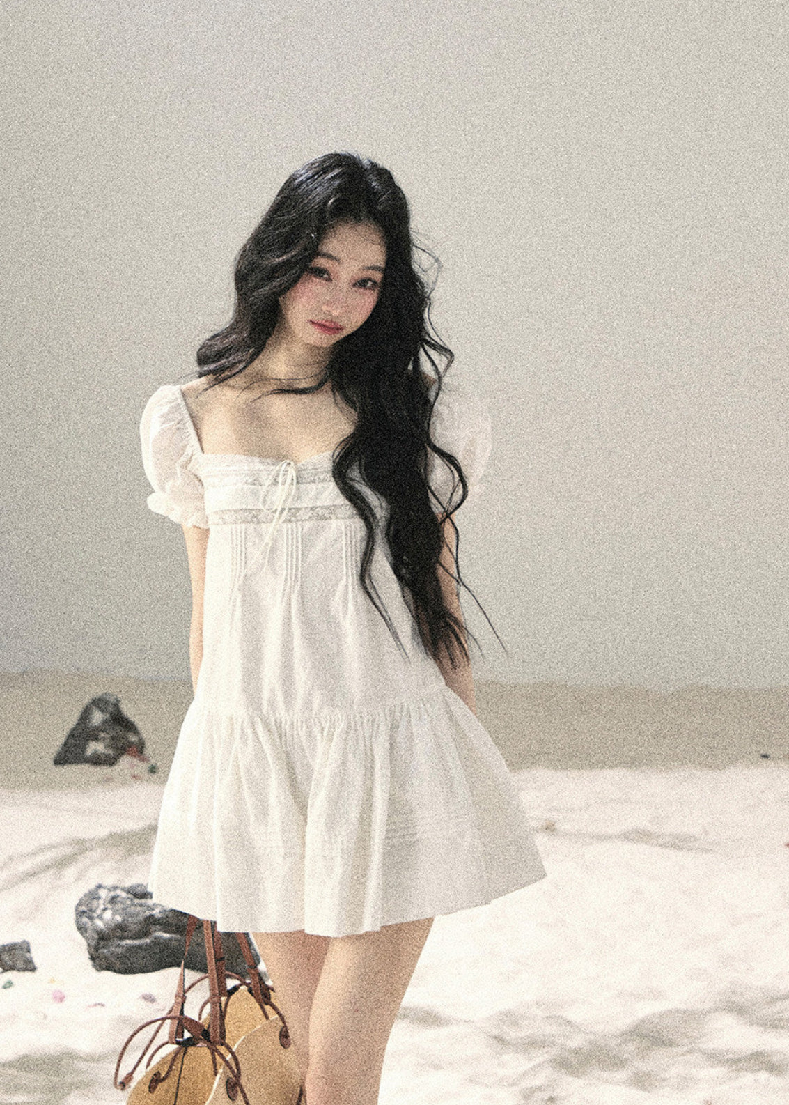 Soft white babydoll dress styled with a woven bag