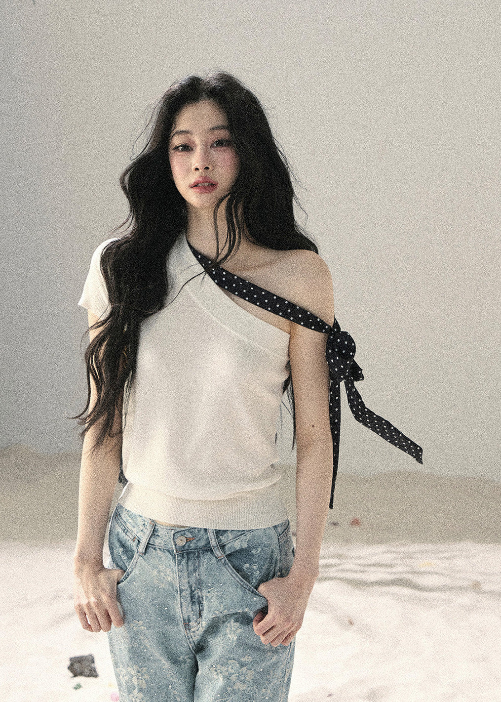 White one-shoulder knit top with black polka dot ribbon detail