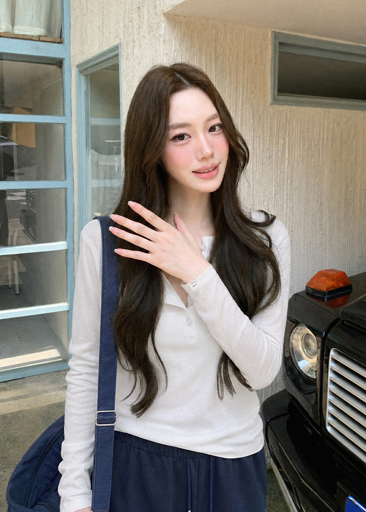 Model wearing a black Tencel-wool Henley long-sleeve top