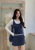 Model wearing a navy and white faux-layered top with a drawstring mini skirt