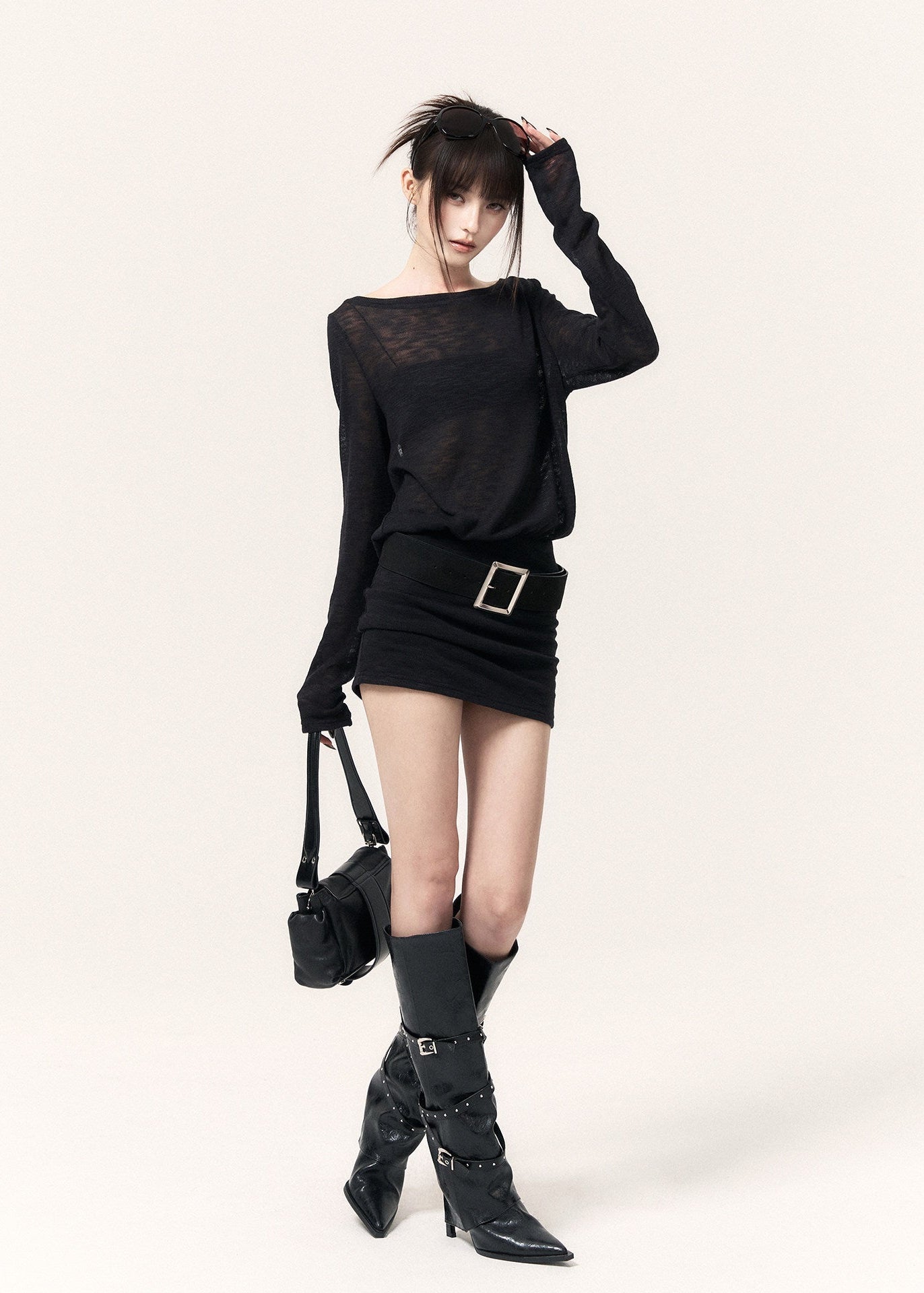 Back view of a black open-back dress with cross straps and a metal pendant