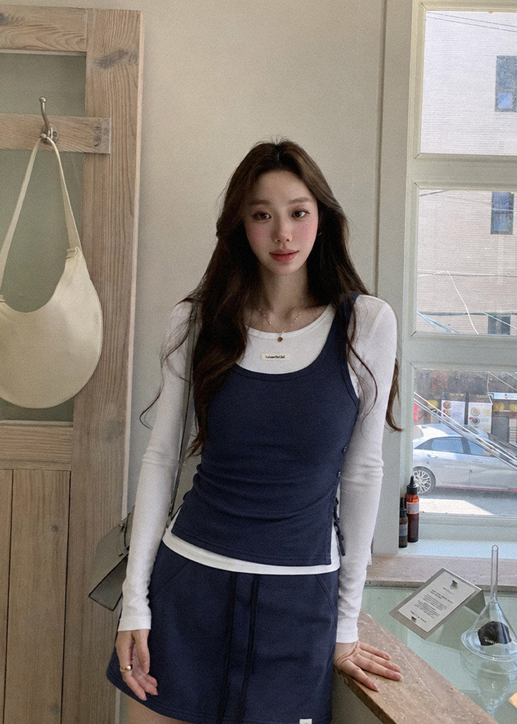 Model wearing a navy and white faux-layered top with a drawstring mini skirt