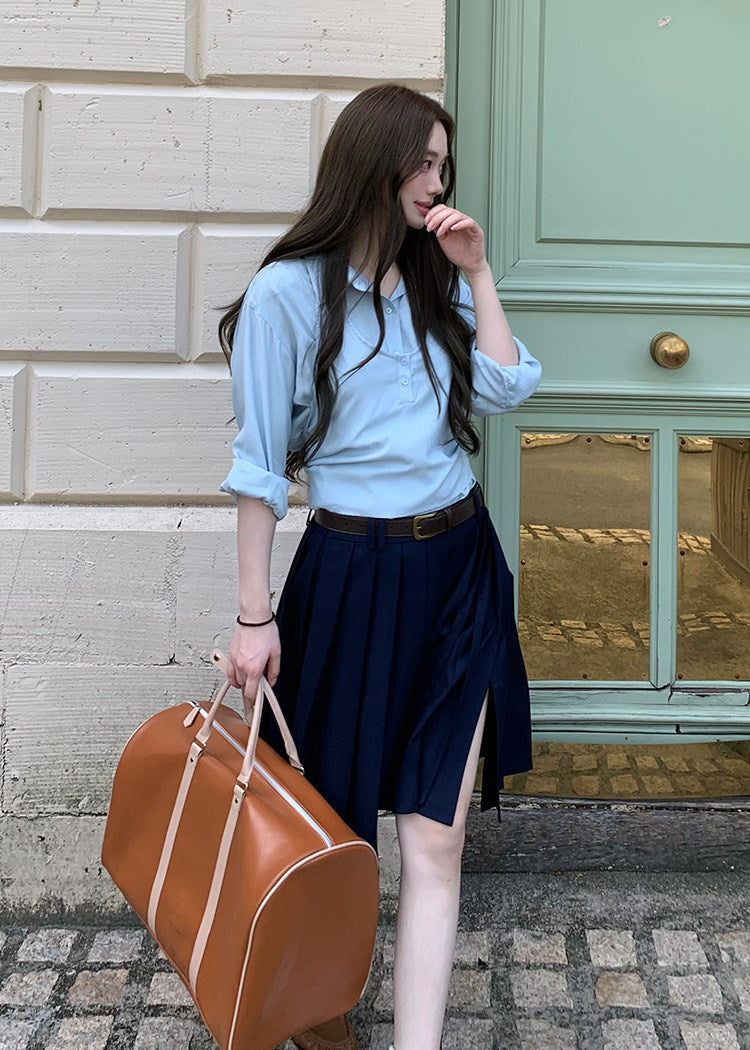 Navy pleated skirt with an asymmetric hem styled with knee-high socks and brown loafers