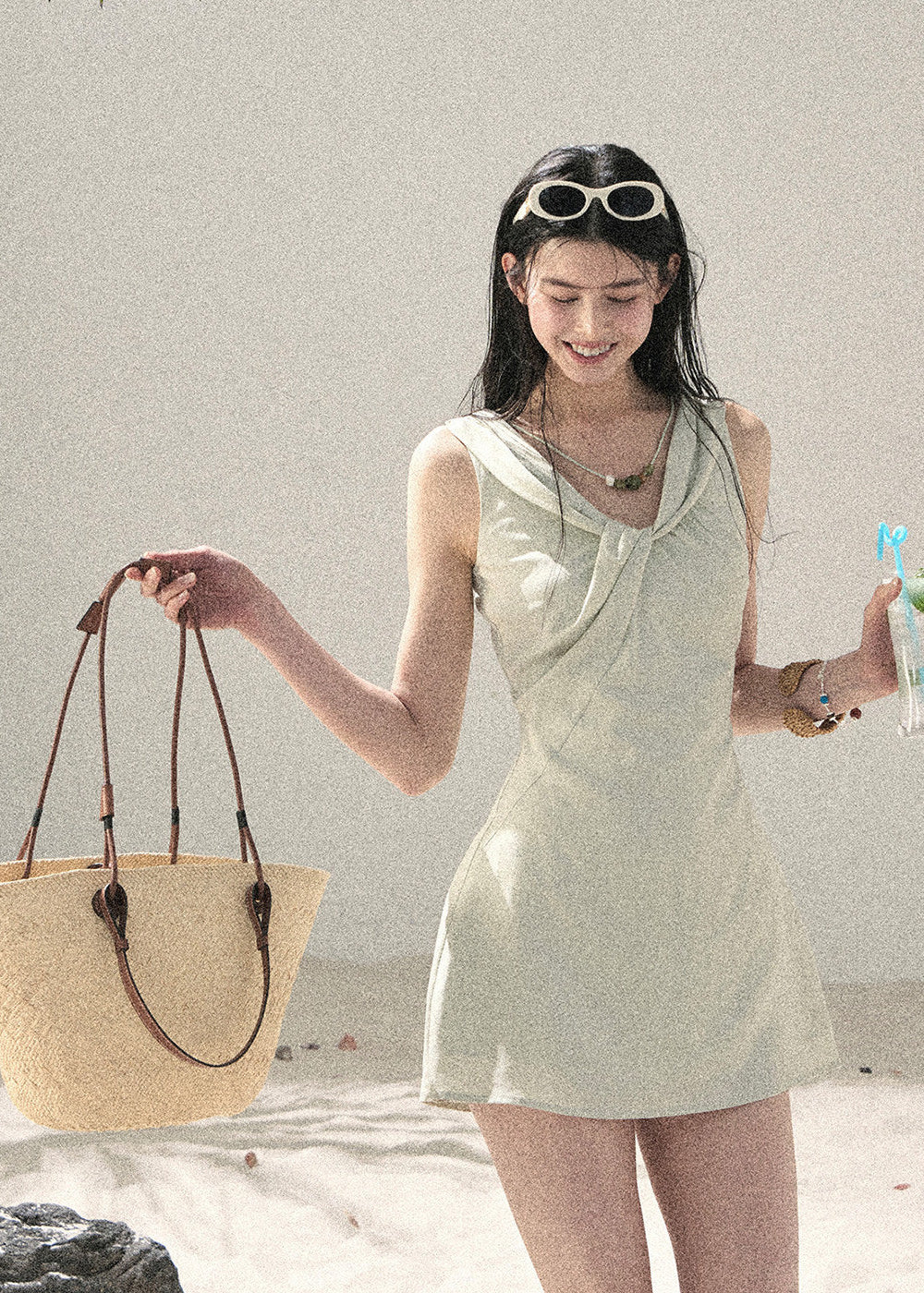 Sage green sleeveless dress styled with a woven beach bag