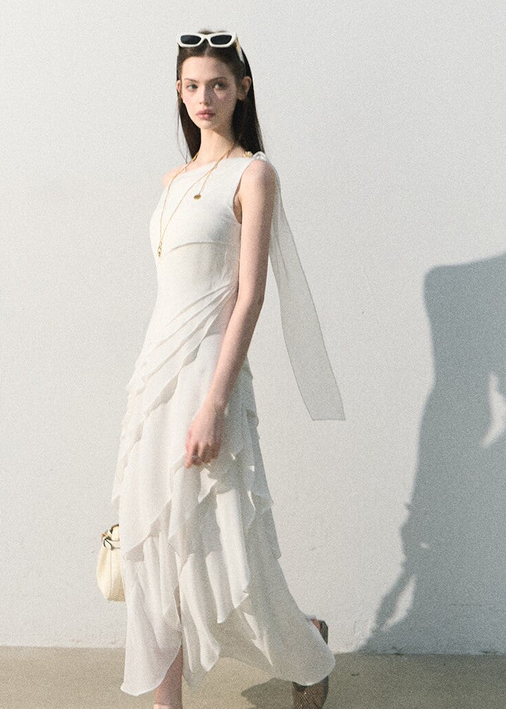Model wearing a one-shoulder long dress by the water