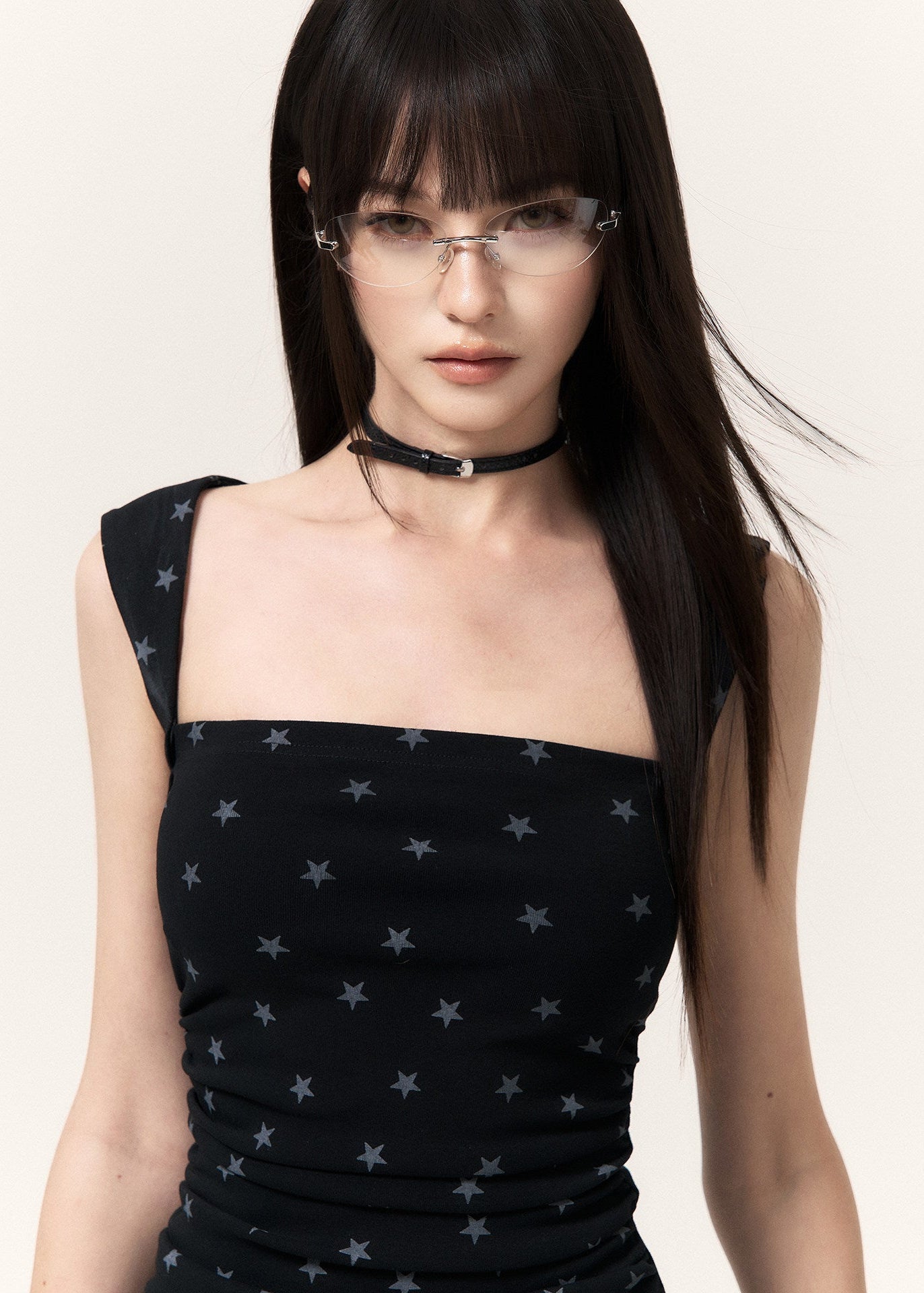 Model wearing a black star print mini dress with knee-high boots