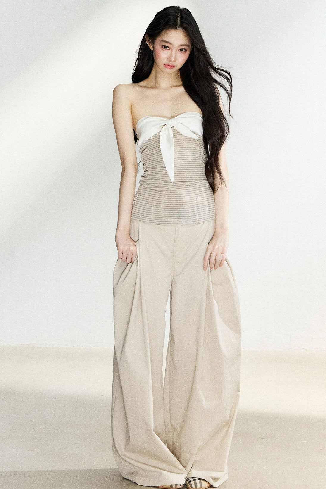 Beige high-waisted wide-leg trousers with side pleats