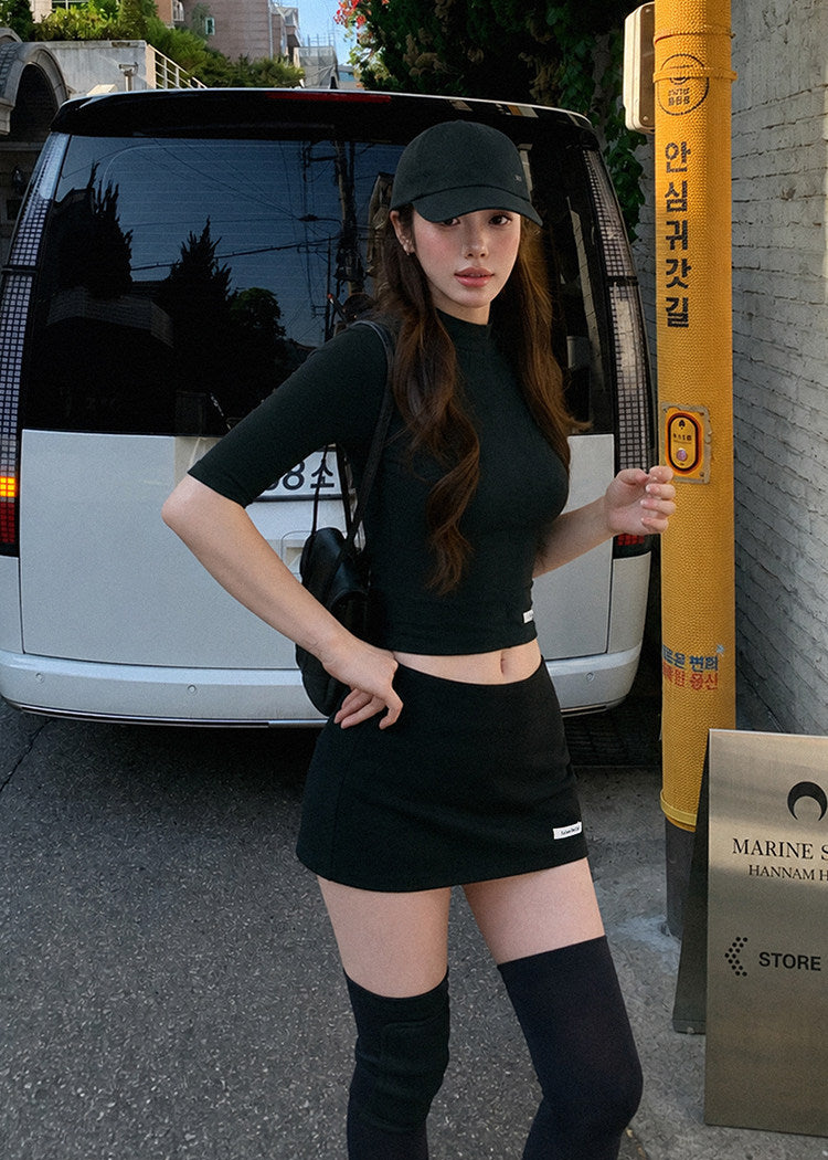 Black fitted mid-sleeve top with a matching A-line mini skirt
