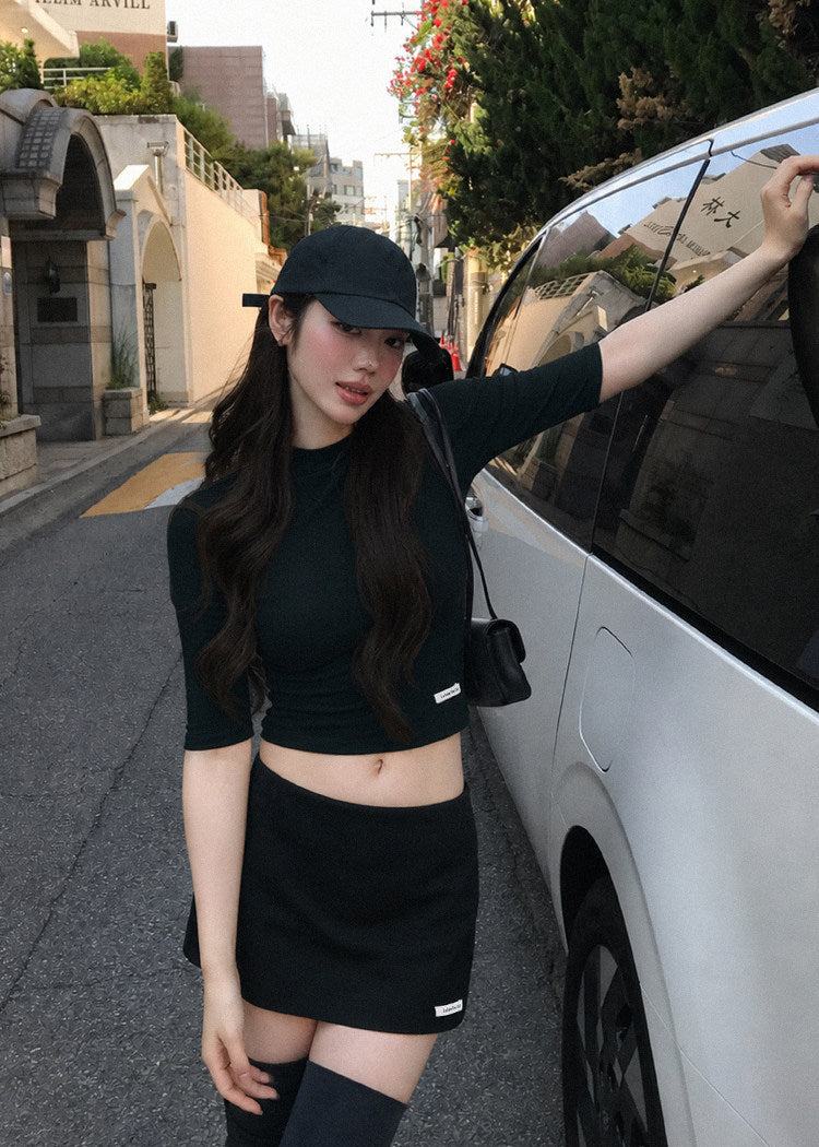 Black fitted mid-sleeve top with a matching A-line mini skirt
