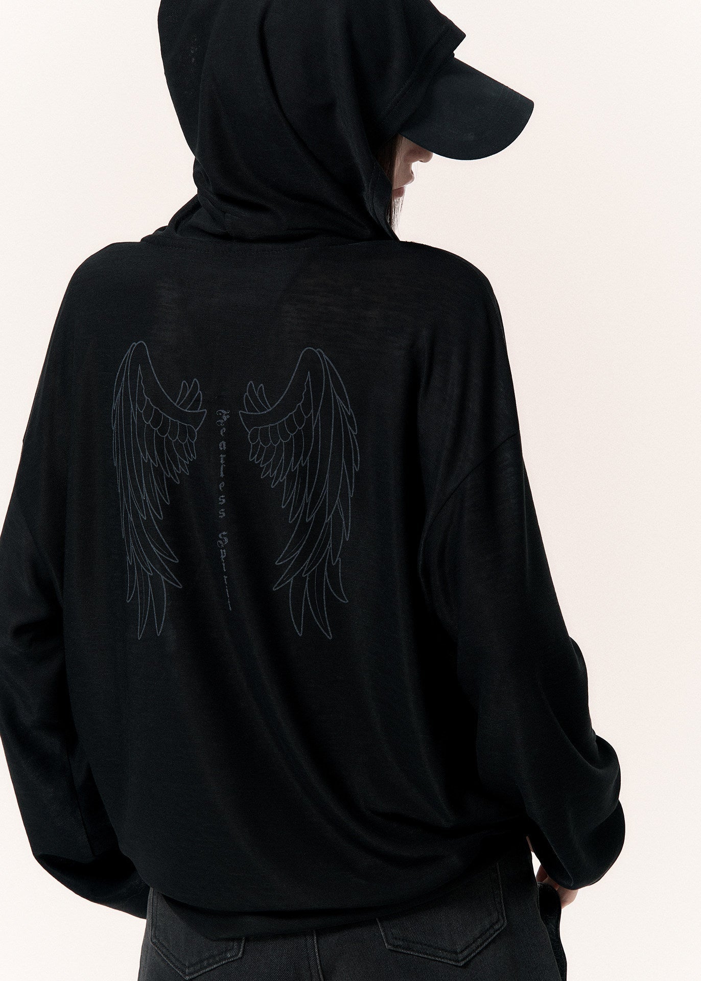 Oversized black zip-up hoodie with long sleeves and a cross-shaped zipper pull