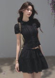 Black fitted top with a matching tiered cake mini skirt