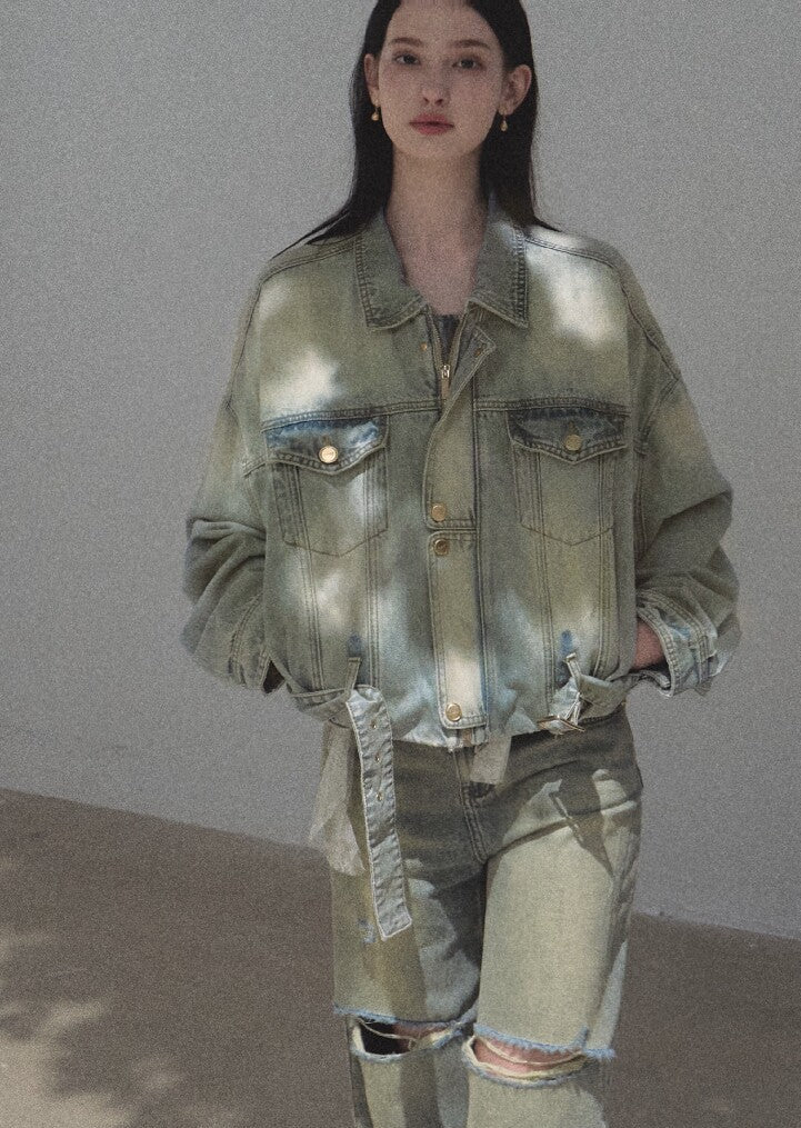Model wearing a loose distressed denim jacket with matching faded jeans