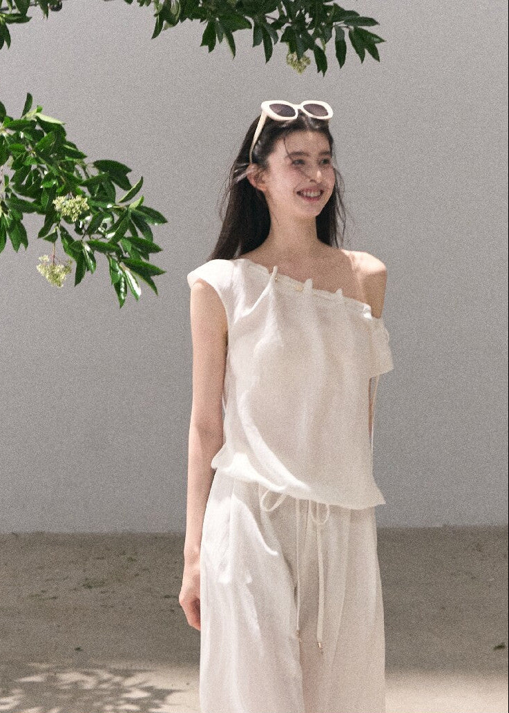 Asymmetric off-shoulder top styled with relaxed pants