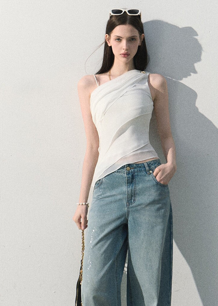 Model wearing a fitted asymmetric white sleeveless top