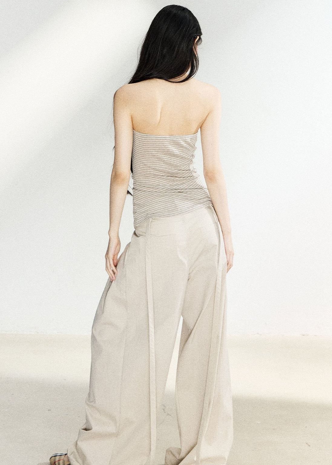 Beige high-waisted wide-leg trousers with side pleats