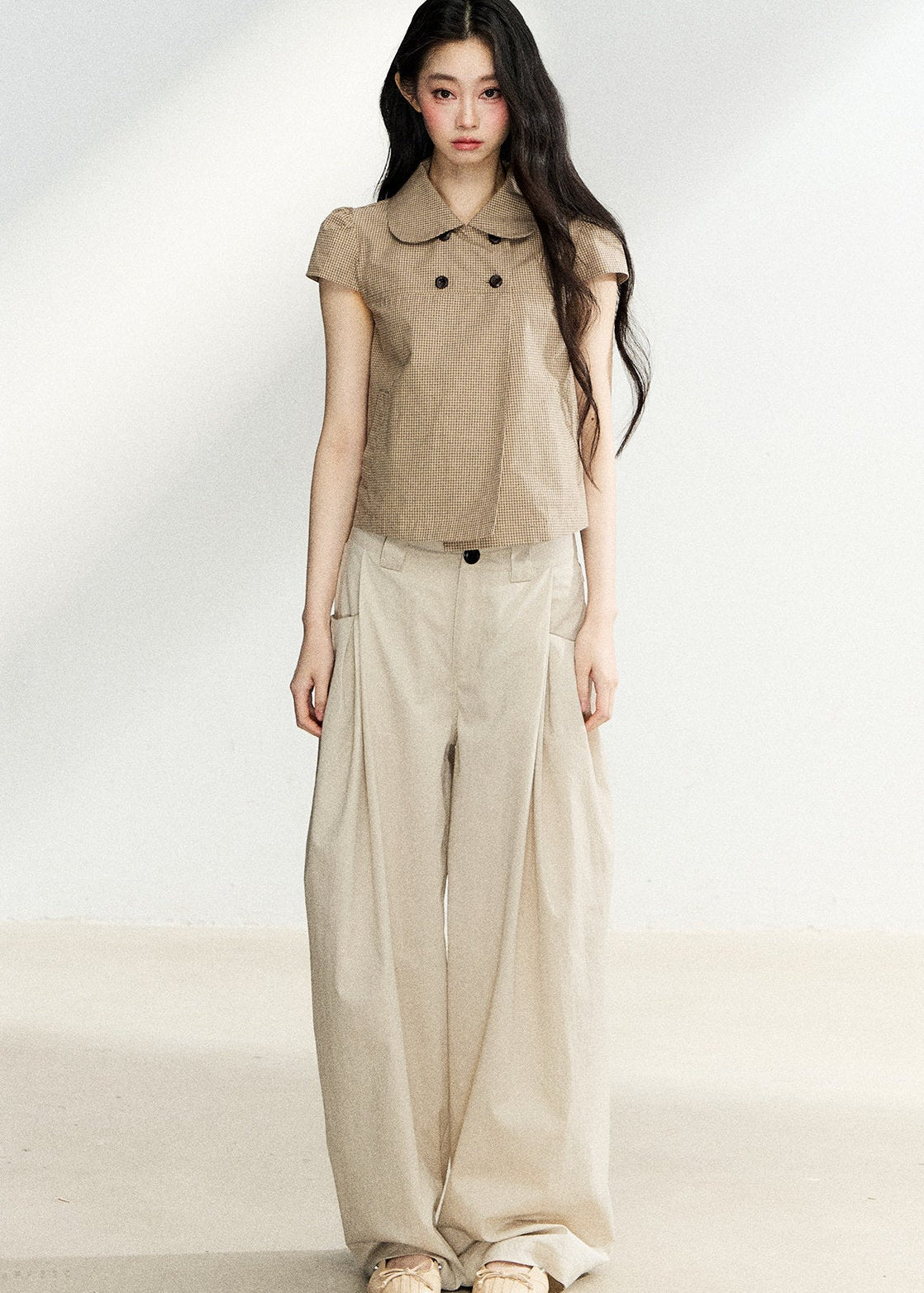 Beige high-waisted wide-leg trousers with side pleats