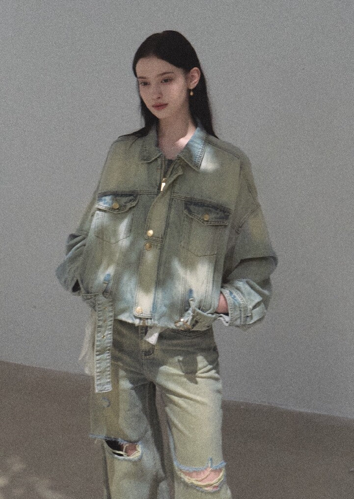 Model wearing a loose distressed denim jacket with matching faded jeans