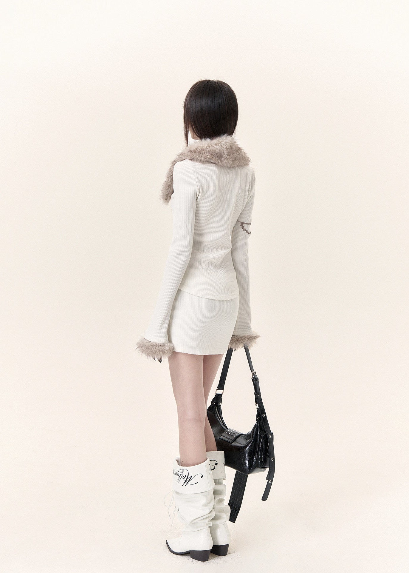 White long sleeve knit top with beige faux fur trim and fitted mini skirt