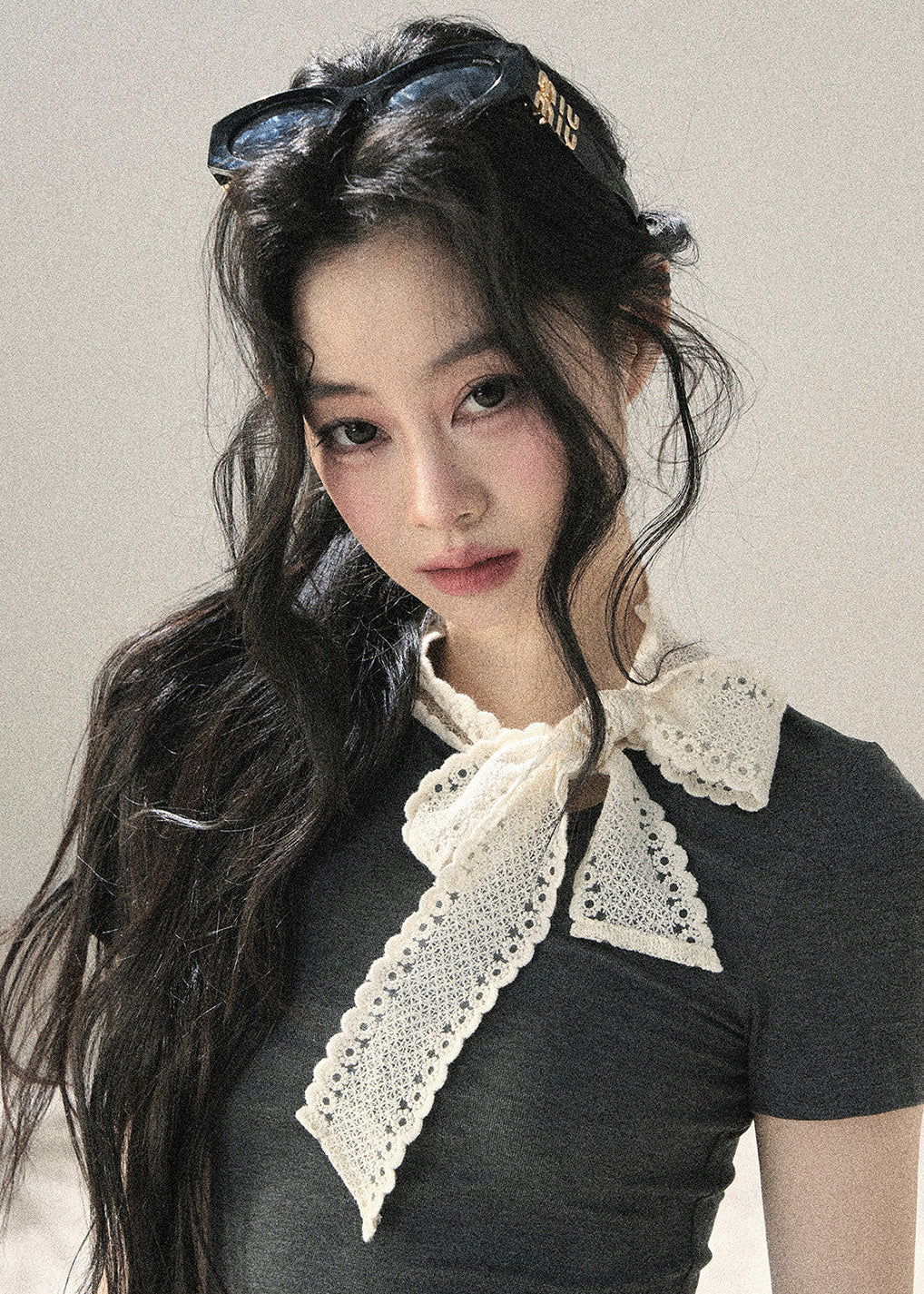 Woman wearing gray fitted T-shirt with contrast white lace ribbon bow