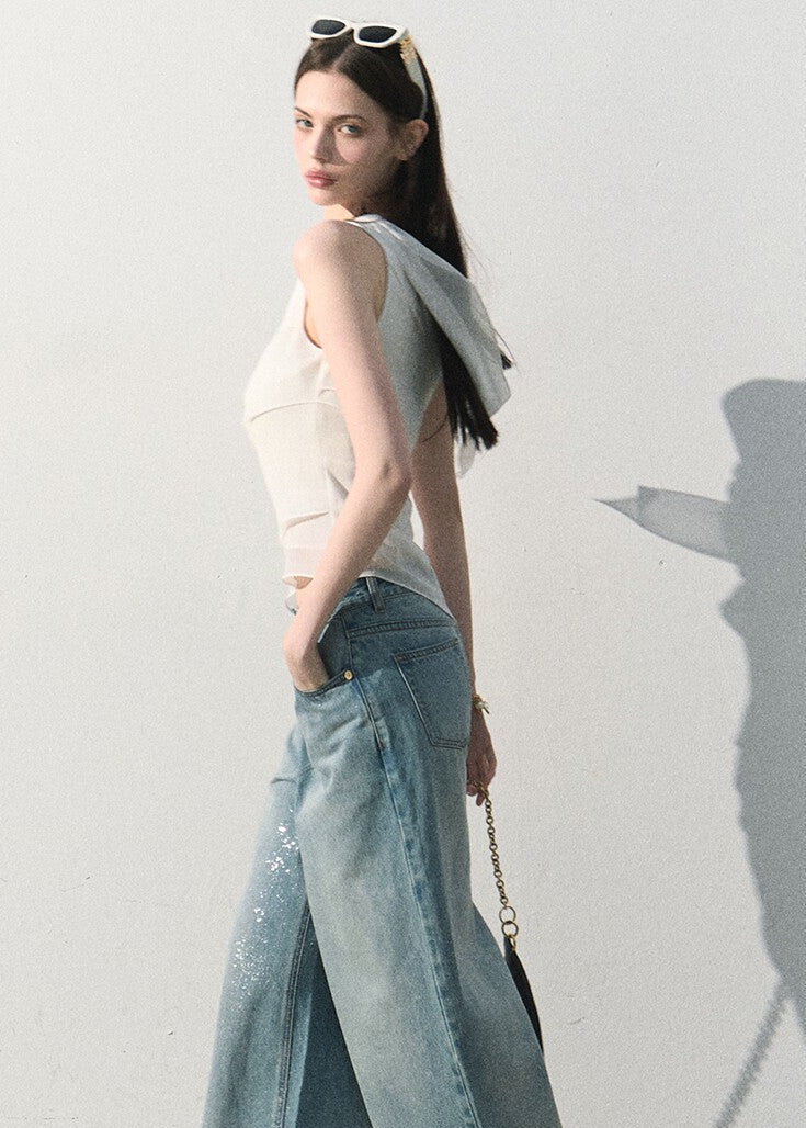 Model wearing a fitted asymmetric white sleeveless top