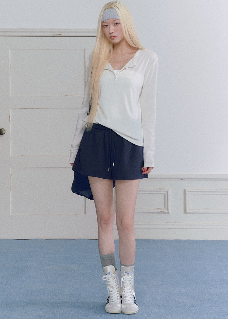 Model wearing a black Tencel-wool Henley long-sleeve top