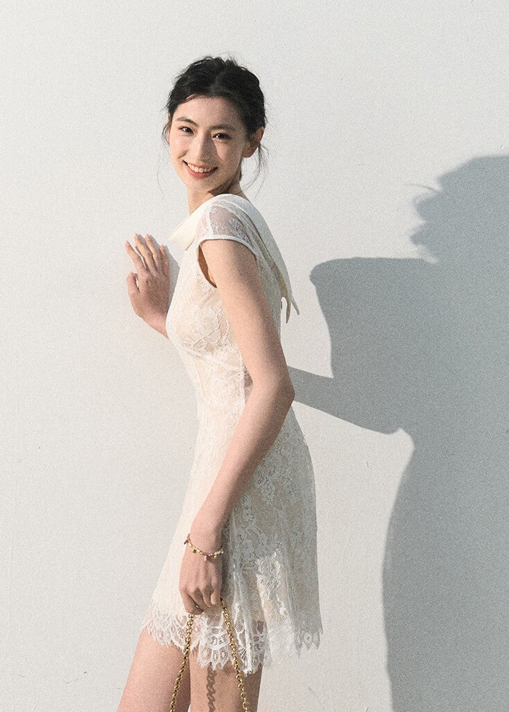 Elegant ivory lace dress styled with a light handbag