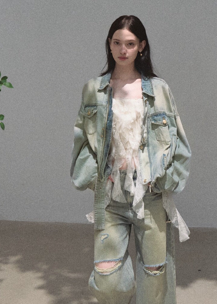Model wearing a loose distressed denim jacket with matching faded jeans