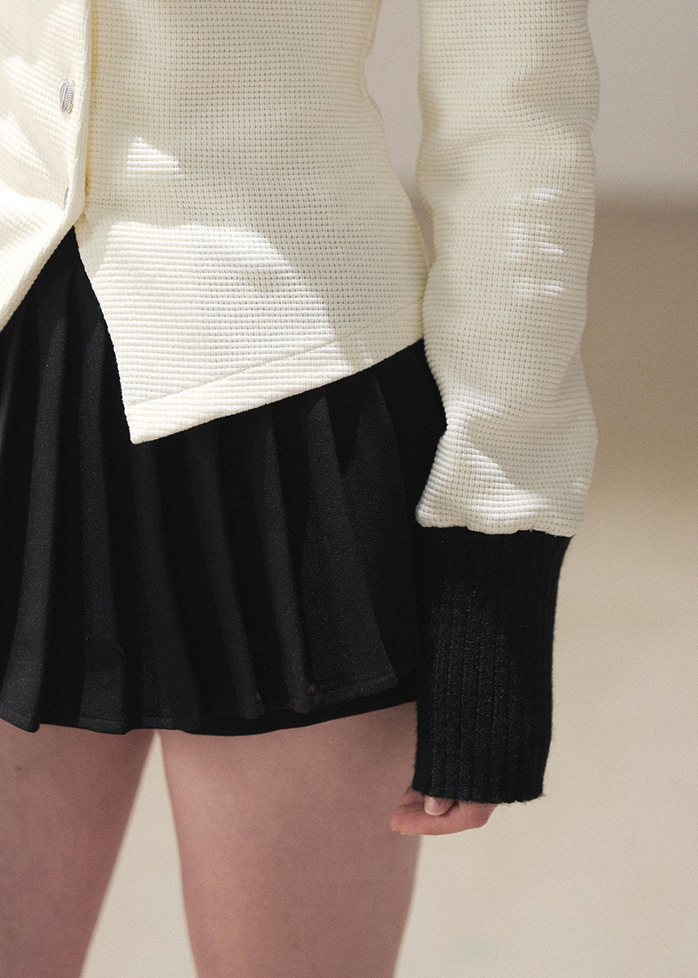 Classic black and ivory cardigan skirt set with fitted waist silhouette