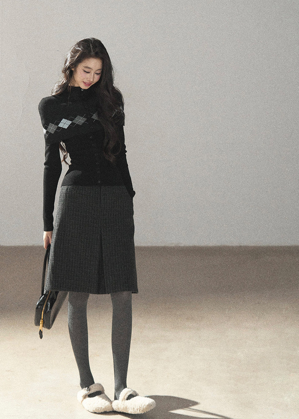 Vintage collegiate-inspired argyle knit cardigan styled with grey skirt
