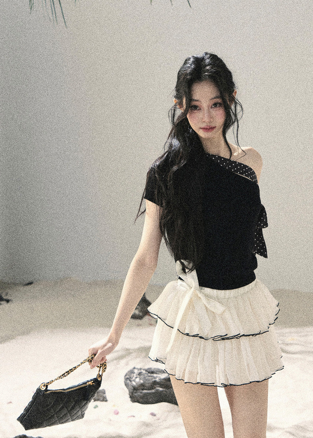 Black one-shoulder knit top with polka dot ribbon bow detail