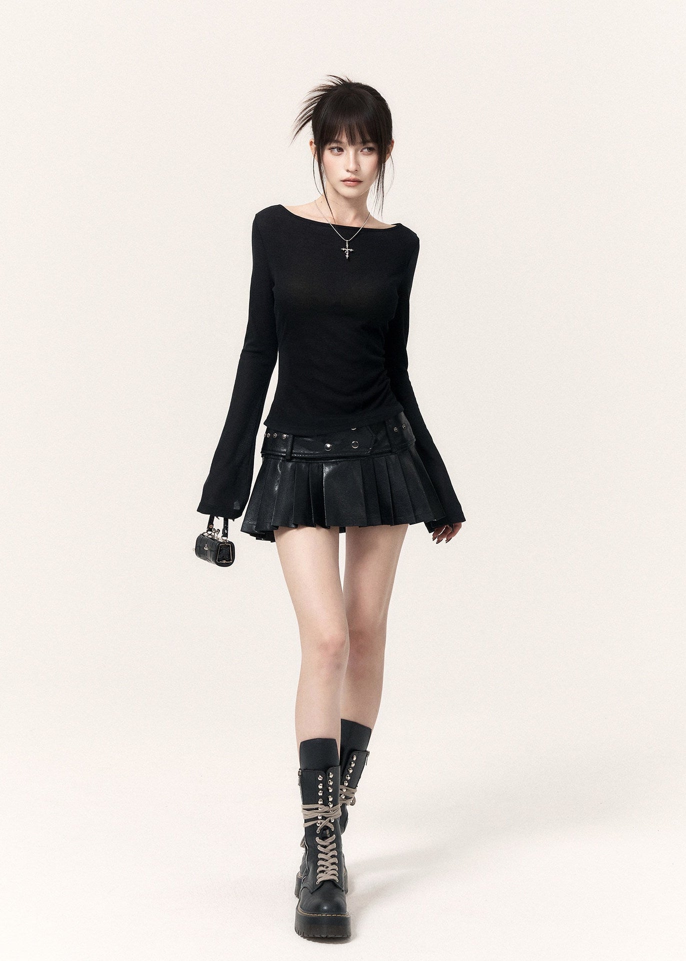 Black fitted long-sleeve top with flared cuffs styled with a pleated mini skirt